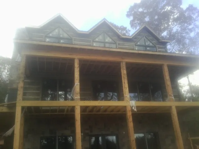 Dormers and porch framing on a large log home under construction in Wawarsing