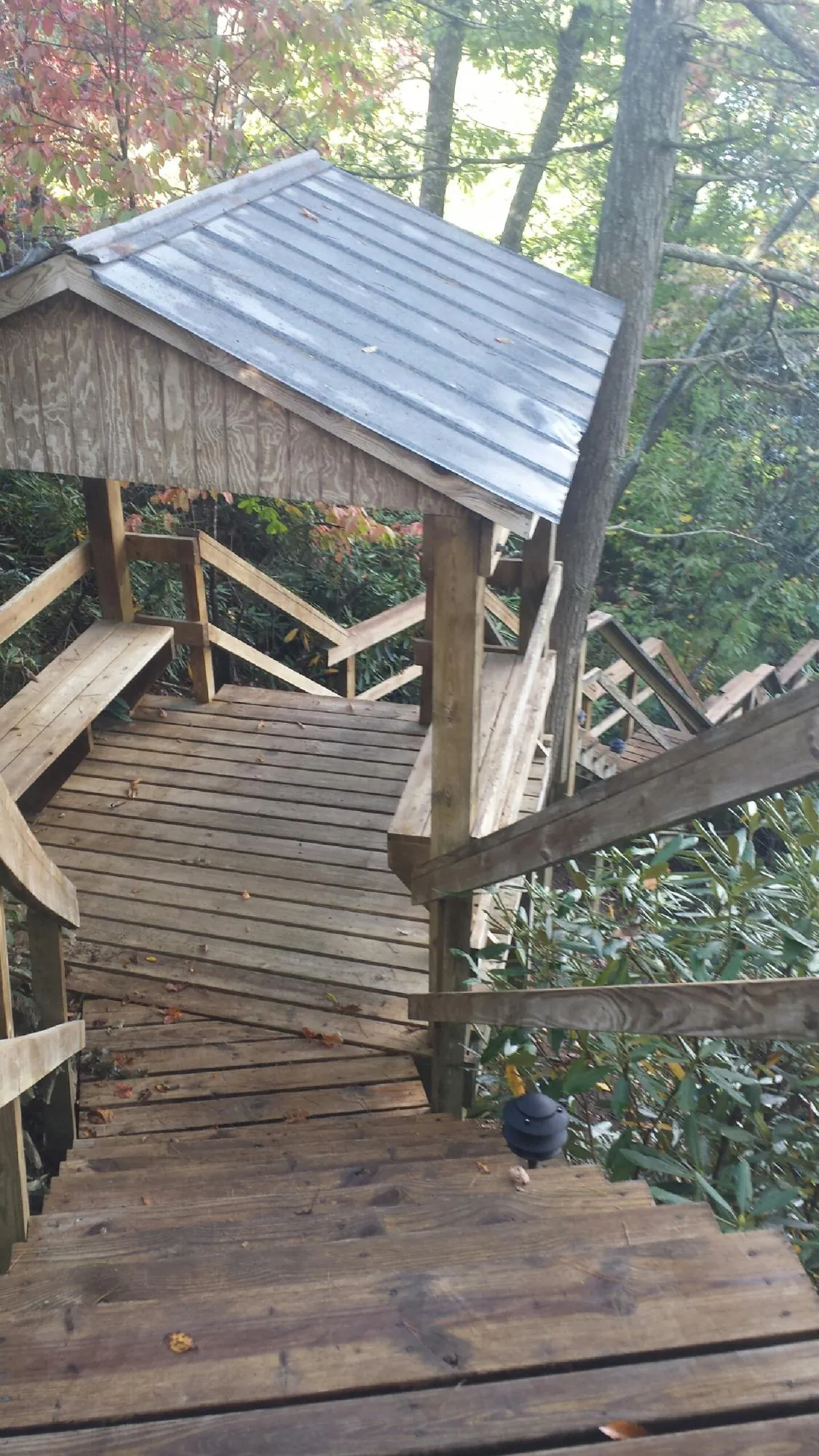 Metal roofed shelter over wooden steps on a wooded walkway — Skylight Repair & Installation work by our crew in Wawarsing